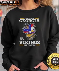 Cozy sweatshirt reading 'I May Live In Georgia But I'm A Minnesota Vikings Fan Forever' perfect for fans.