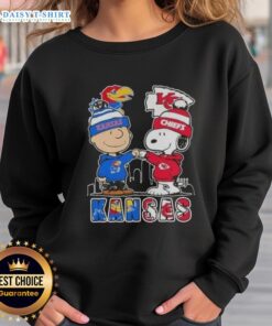 Kansas City skyline sweatshirt featuring Snoopy and Charlie Brown supporting Jayhawks and Chiefs sports teams.