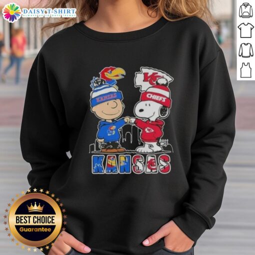 Kansas City skyline sweatshirt featuring Snoopy and Charlie Brown supporting Jayhawks and Chiefs sports teams.