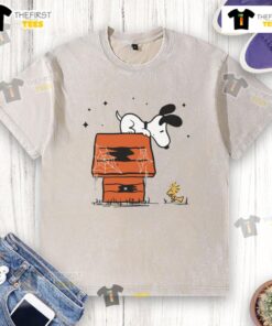 Pretty Snoopy and Woodstock haunted doghouse design on a washed t-shirt, perfect for Halloween fans and Peanuts lovers.