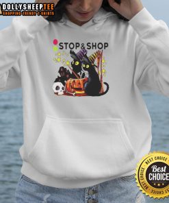 Pretty black cat witch with pumpkin by a haunted house on a Halloween hoodie design.