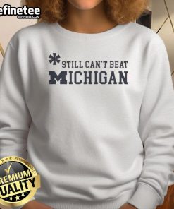 Top Asterisk Still Can't Beat Michigan Wolverines Sweatshirt featuring team colors and logo, perfect for fans.