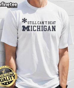 Top Asterisk Still Can't Beat Michigan Wolverines T-Shirt featuring bold graphics and vibrant colors for fans.