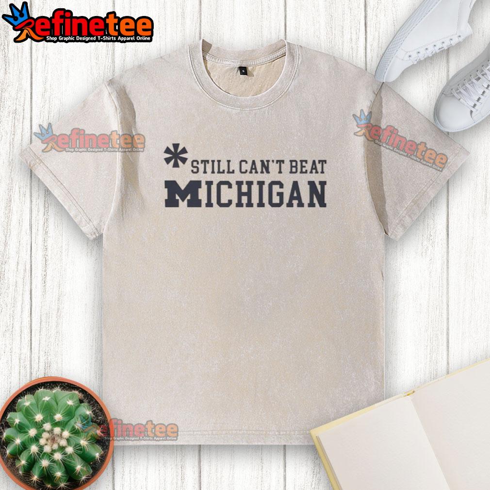 Top Asterisk Still Can'T Beat Michigan Wolverines Washed T Shirt Top Asterisk Still Can't Beat Michigan Wolverines washed t-shirt featuring bold team logo and stylish design.