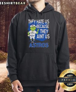Top Houston Astros Grinch Christmas hoodie featuring 'They Hate Us Ain't Us' graphic in festive colors.