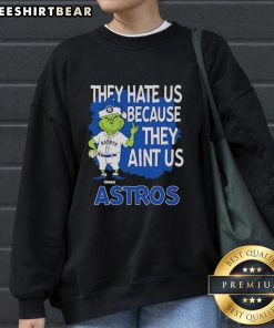 Top Houston Astros Grinch Christmas sweatshirt featuring 'They Hate Us Ain't Us' design for festive baseball fans.
