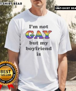 Top I'M Not Gay But My Boyfriend Is T-Shirt displayed on a hanger, showcasing a playful LGBTQ+ themed design.
