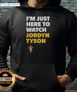Alt Text: Jordyn Tyson wearing 'Im Just Here To Watch' hoodie, showcasing stylish streetwear for casual outfits.