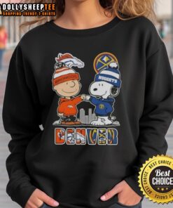 Alt Text: Cozy sweatshirt featuring Snoopy, Charlie Brown, Denver Broncos, and Nuggets skyline design for sports fans.