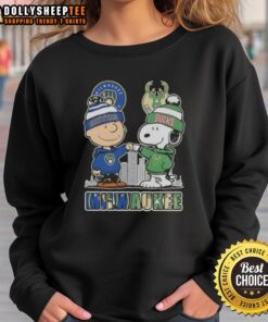 Alt Text: Cozy sweatshirt featuring Snoopy and Charlie Brown, celebrating Milwaukee Brewers and Bucks with city skyline design.
