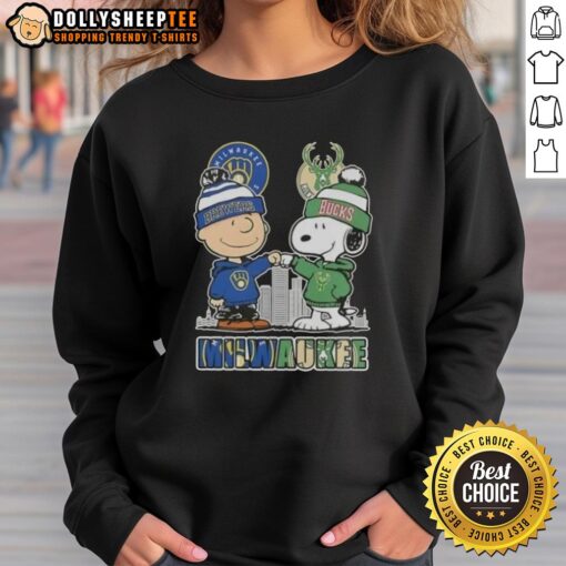 Alt Text: Cozy sweatshirt featuring Snoopy and Charlie Brown, celebrating Milwaukee Brewers and Bucks with city skyline design.
