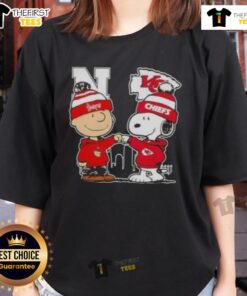 Alt Text: Top Snoopy and Charlie Brown Nebraska Huskers x Kansas City Chiefs skyline ladies tee design featuring iconic characters.