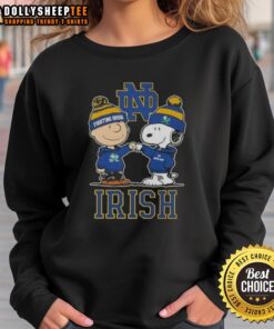Top Snoopy and Charlie Brown Notre Dame Fighting Irish football skyline sweatshirt featuring iconic characters and vibrant design.
