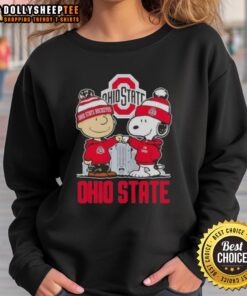 Alt Text: Cozy Ohio State Buckeyes football sweatshirt featuring Snoopy and Charlie Brown against a city skyline backdrop.