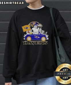 Snoopy and Woodstock driving a car in front of the Baltimore Ravens city skyline on a cozy sweatshirt.