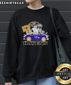 Snoopy driving a car in Baltimore Ravens football sweatshirt, showcasing team spirit and playful design.