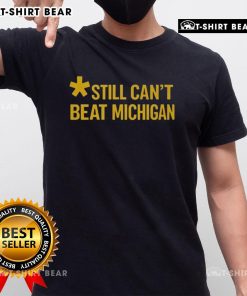 Top Still Can't Beat Michigan T-Shirt featuring bold graphics and a sporty design, perfect for Wolverines fans.