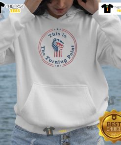 Charlie Kirk wearing a 'Top This is the Turning Point' hoodie with a fist and US flag design, symbolizing patriotism.
