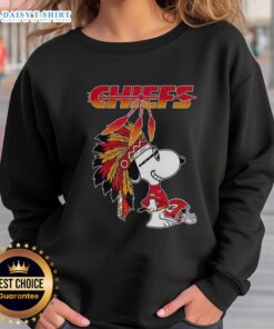 Alt Text: Cute Snoopy in war bonnets on Kansas City Chiefs football helmet sweatshirt, perfect for fans and cozy style lovers.
