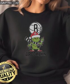 Brooklyn Nets Christmas sweatshirt featuring a Grinch and Santa hat design, perfect for the 2025 holiday season.