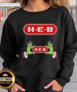 Awesome Grinch hands on a festive H-E-B Christmas sweatshirt, perfect for holiday cheer and seasonal celebrations.
