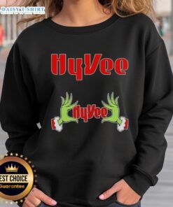 Alt Text: Awesome Grinch hands on a festive Hy-Vee Christmas sweatshirt, perfect for holiday celebrations and cozy winter wear.