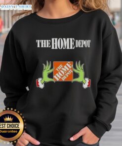 Alt Text: Awesome Grinch hands holding a mug, featuring The Home Depot Christmas sweatshirt design in festive colors.