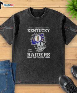 Awesome washed t-shirt featuring 'I may live in Kentucky, but I'm a Raiders fan forever' design for football enthusiasts.