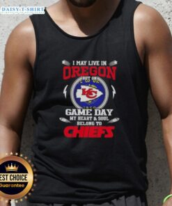 Cheerful fan wearing a Kansas City Chiefs tank top, showcasing pride while living in Oregon on game day.