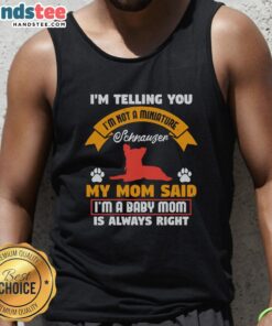Adorable puppy wearing a tank top that says 'I'm Not A Miniature Schnauzer' showcasing its playful personality.