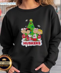 Alt Text: Awesome Peanuts characters Christmas sweatshirt featuring Nebraska Cornhuskers design, perfect for holiday cheer.
