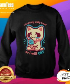 Cute cat wearing a sweatshirt that says I Need My Daily Treat Or I'll Cry highlighting its playful personality.