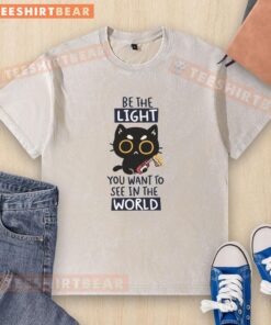 Funny cat on a washed t-shirt with 'Be the light you want to see in the world' printed, perfect for cat lovers.