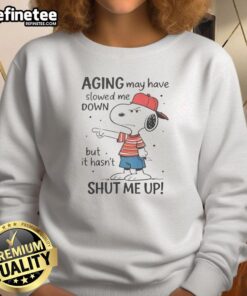 Funny Snoopy sweatshirt featuring the phrase 'Aging May Have Slowed Me Down, But It Hasn't Shut Me Up' for playful style.