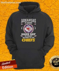 Person wearing a Kansas City Chiefs hoodie, proudly showing support on game day, with Arkansas backdrop.
