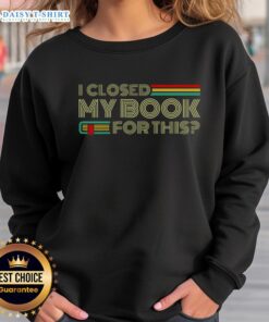 Cozy 'Good I Closed My Book For This' sweatshirt on a wooden table, perfect for book lovers and reading enthusiasts.