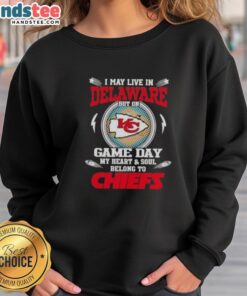 Cheerful fan wearing a Kansas City Chiefs sweatshirt, showing team spirit despite living in Delaware on game day.