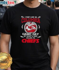 Fan wearing 'Good I May Live In DC But My Heart Belongs To Kansas City Chiefs' T-Shirt on Game Day, showcasing team spirit.