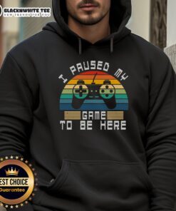 Retro vintage gamer hoodie featuring 'Good I Paused My Game To Be Here' design against a sunset backdrop.