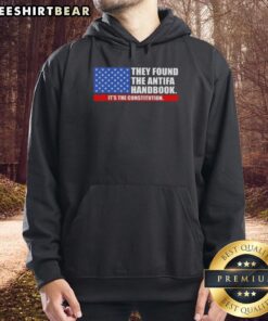 Person wearing a 'Good They Found The Handbook It's The Constitution' hoodie with the US flag design, showcasing patriotic style.