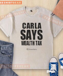 Happy Carla wearing a Wealth Tax washed T-shirt, smiling confidently against a vibrant backdrop.