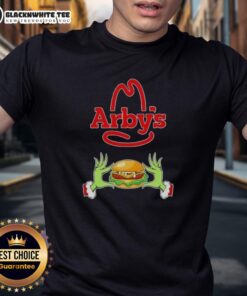 Happy Grinch hands holding a heart on an Arby's Merry Christmas T-shirt, perfect for festive holiday cheer.