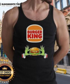 Happy Grinch hands holding a burger at Burger King, wearing a Merry Christmas tank top, festive holiday spirit.