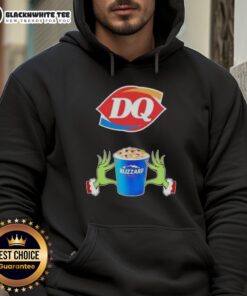 Happy Grinch hands making a heart shape in a Dairy Queen Merry Christmas hoodie, celebrating the festive spirit.