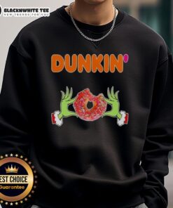 Happy Grinch hands holding a Dunkin' Donut on a Merry Christmas sweatshirt, perfect for festive holiday cheer.