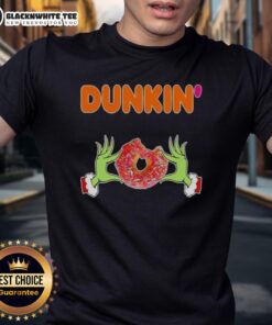 Happy Grinch hands holding a Dunkin' Donut on a festive Merry Christmas T-Shirt, perfect for holiday cheer.