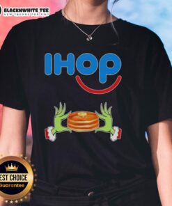 Happy Grinch hands forming a heart shape on a Merry Christmas ladies tee from IHOP, perfect for festive holiday cheer.