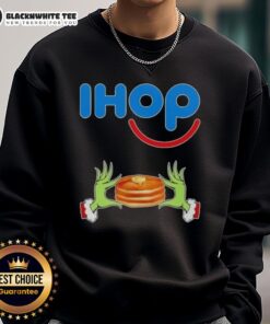 Happy Grinch hands forming a heart on a Merry Christmas sweatshirt from IHOP, perfect for festive holiday cheer.