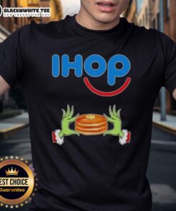 Happy Grinch hands forming a heart on a Merry Christmas IHOP T-shirt, perfect for holiday celebrations and festive cheer.