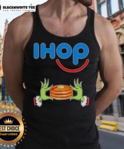 Happy Grinch hands holding a heart, wearing a Merry Christmas tank top at IHOP, festive holiday spirit.